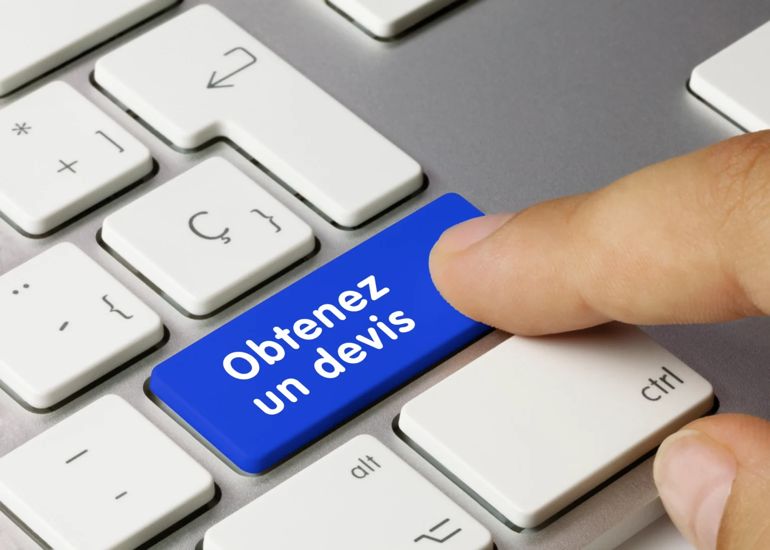 Doigt appuyant sur le bouton 'Obtenez un devis' sur un clavier